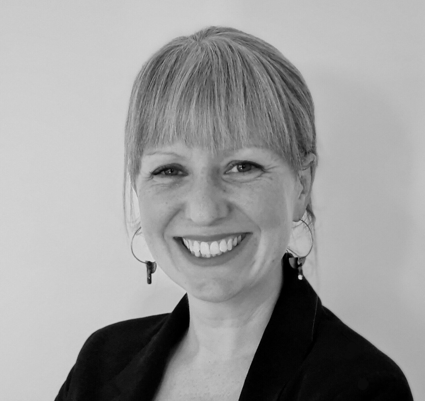Headshot of Lizzie Kenyon, our CEO, in black and white